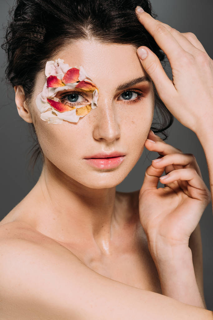beautiful nude woman with floral petals around eye isolated on grey - Photo, Image
