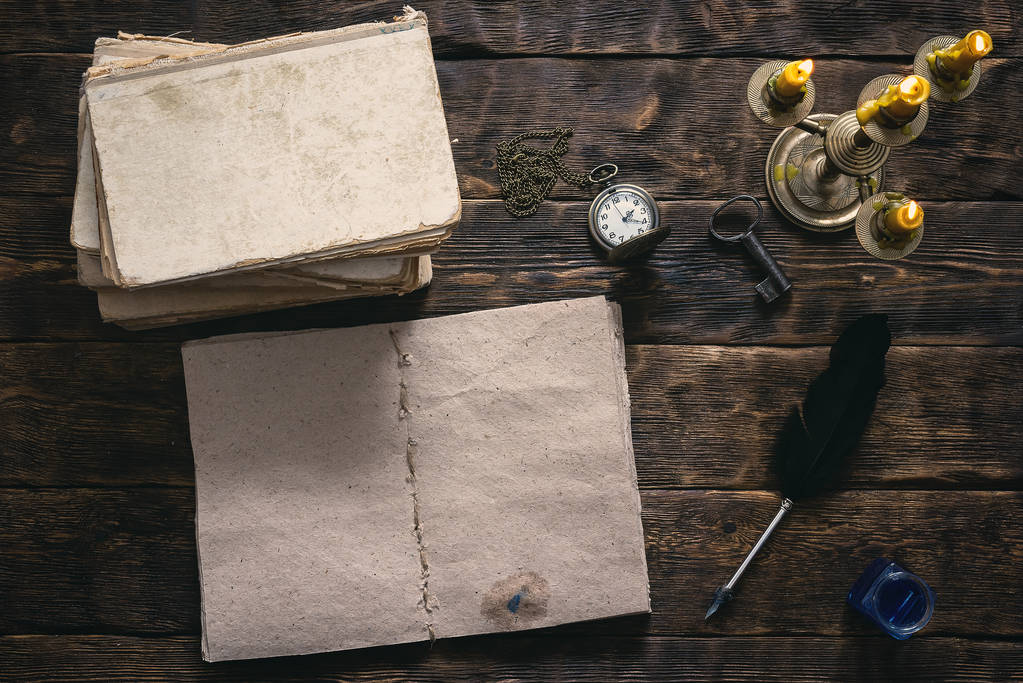 Libro abierto en blanco, literatura antigua, reloj de bolsillo y un tintero con pluma pluma sobre un fondo de mesa de madera escritor
. - Foto, Imagen