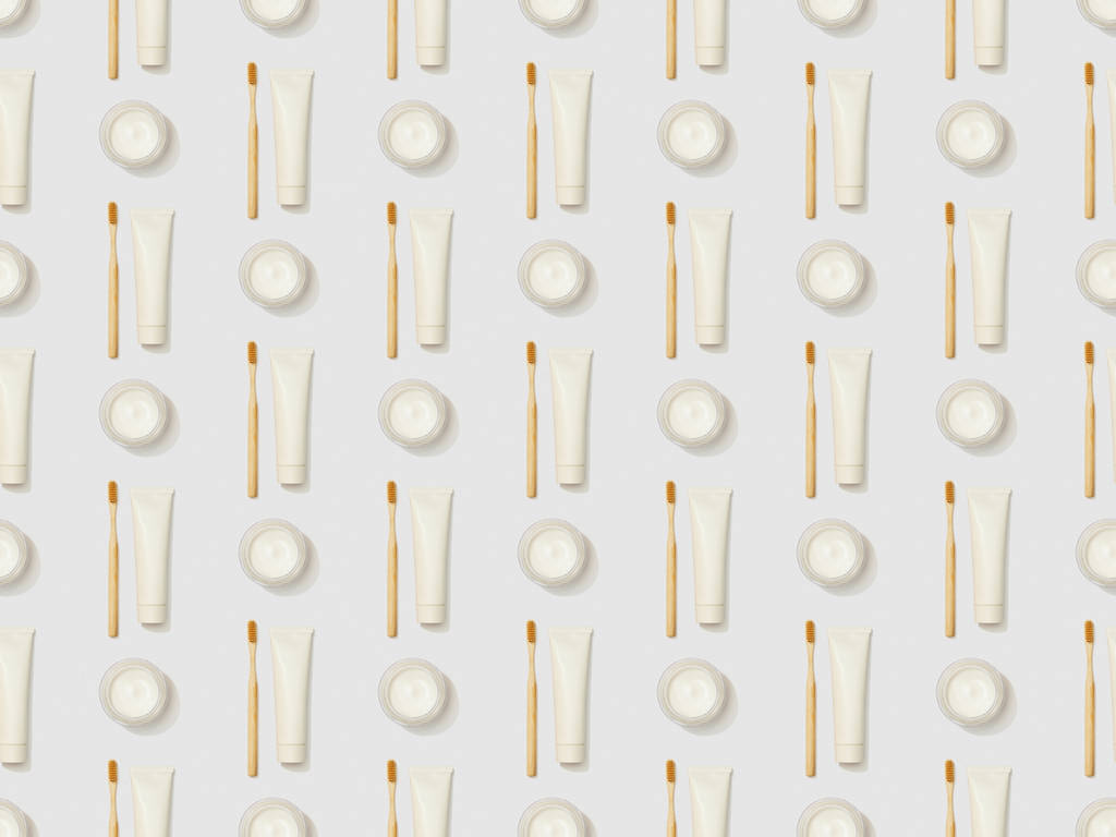 verticalmente escovas de dentes de bambu, pasta de dentes em tubo e creme cosmético em fundo cinza, padrão de fundo sem costura
 - Foto, Imagem