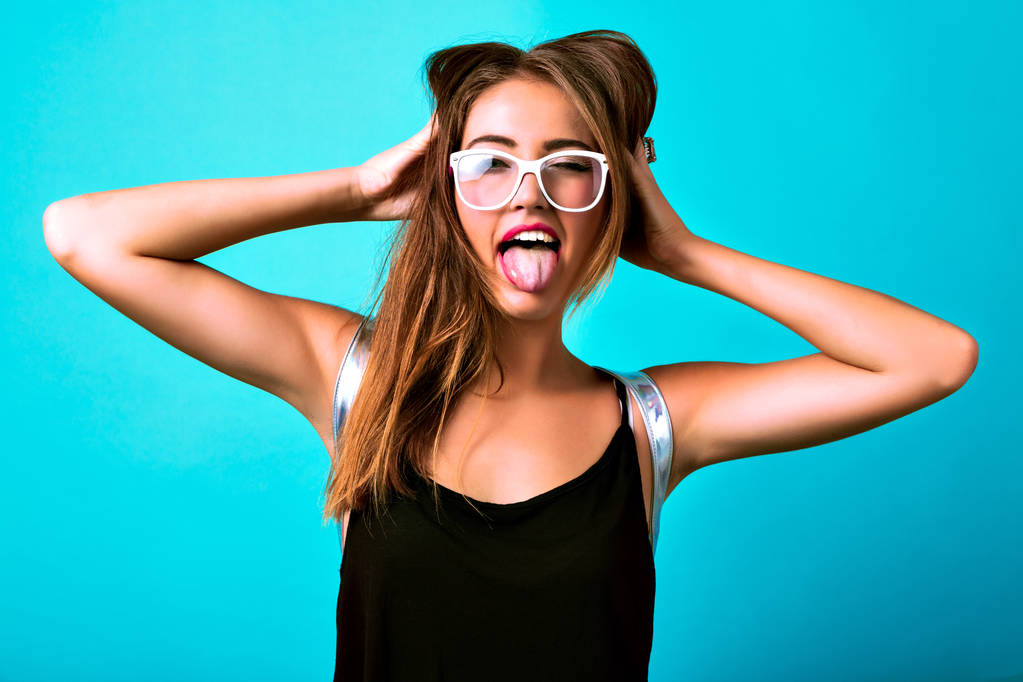 Młoda piękna kobieta w okularach pozowanie język wyświetlone - Zdjęcie, obraz