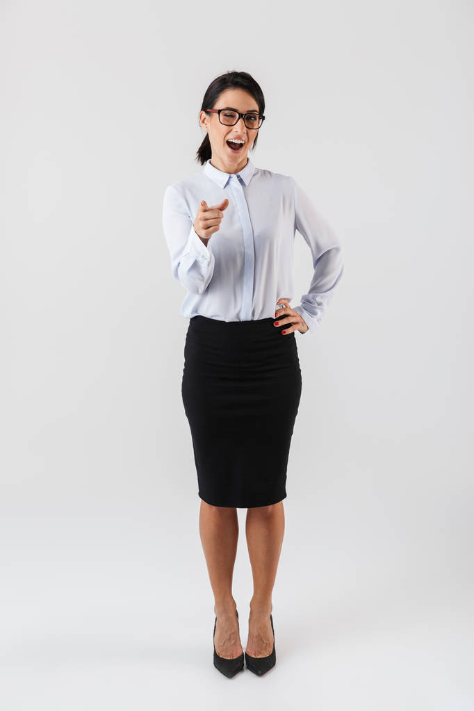 Volle lengte foto van succesvolle zakenvrouw dragen van bril permanent in het kantoor geïsoleerd op witte achtergrond - Foto, afbeelding