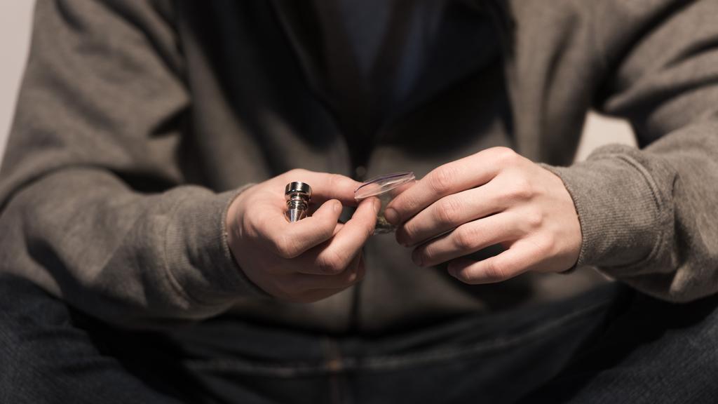 Mann mit Raucherpfeife und Packung Marihuana im Fokus - Foto, Bild