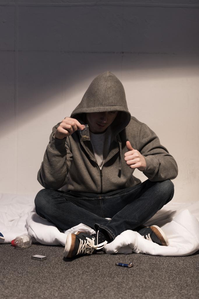 junkie man holding pack of marijuana and showing thumb up - Photo, Image