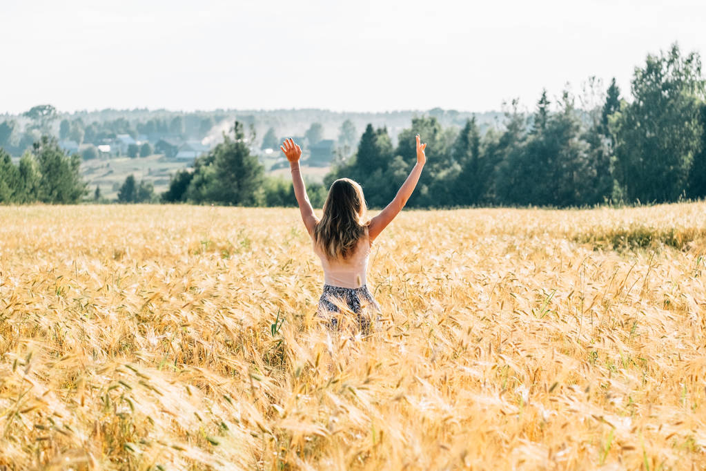 Mladá žena v šatech pěšky podél obilné pole. Pojem štěstí, osamělost, léto, dovolená venkov - Fotografie, Obrázek
