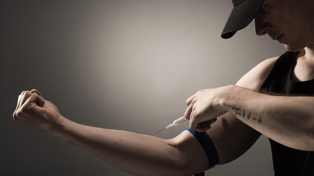 viciado homem fazendo injeção de dose de heroína em fundo cinza
 - Foto, Imagem
