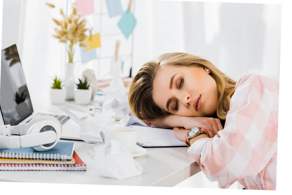 Ξανθιά νεαρή γυναίκα σε καρώ πουκάμισο στον ύπνο στο χώρο εργασίας - Φωτογραφία, εικόνα