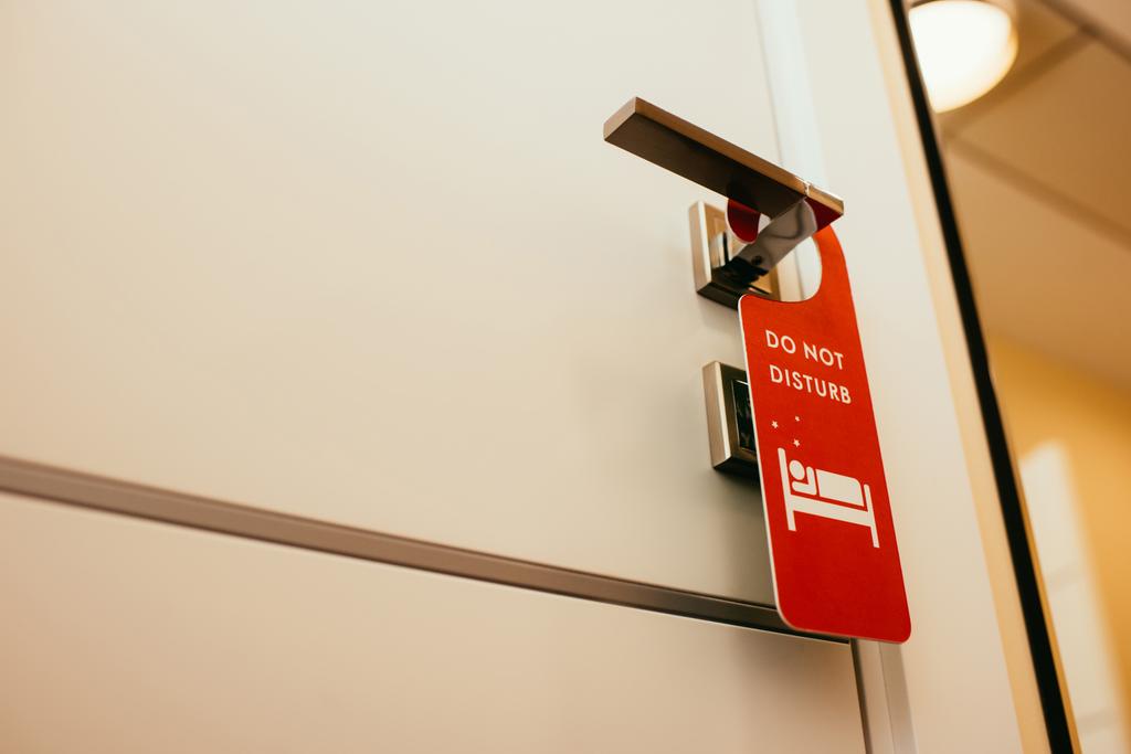 letrero rojo "no molestar" en la manija de la puerta en el hotel
 - Foto, Imagen