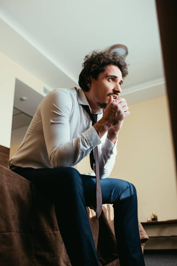 беспокойный бизнесмен в формальной одежде разговаривает на смартфоне в номере отеля
 - Фото, изображение