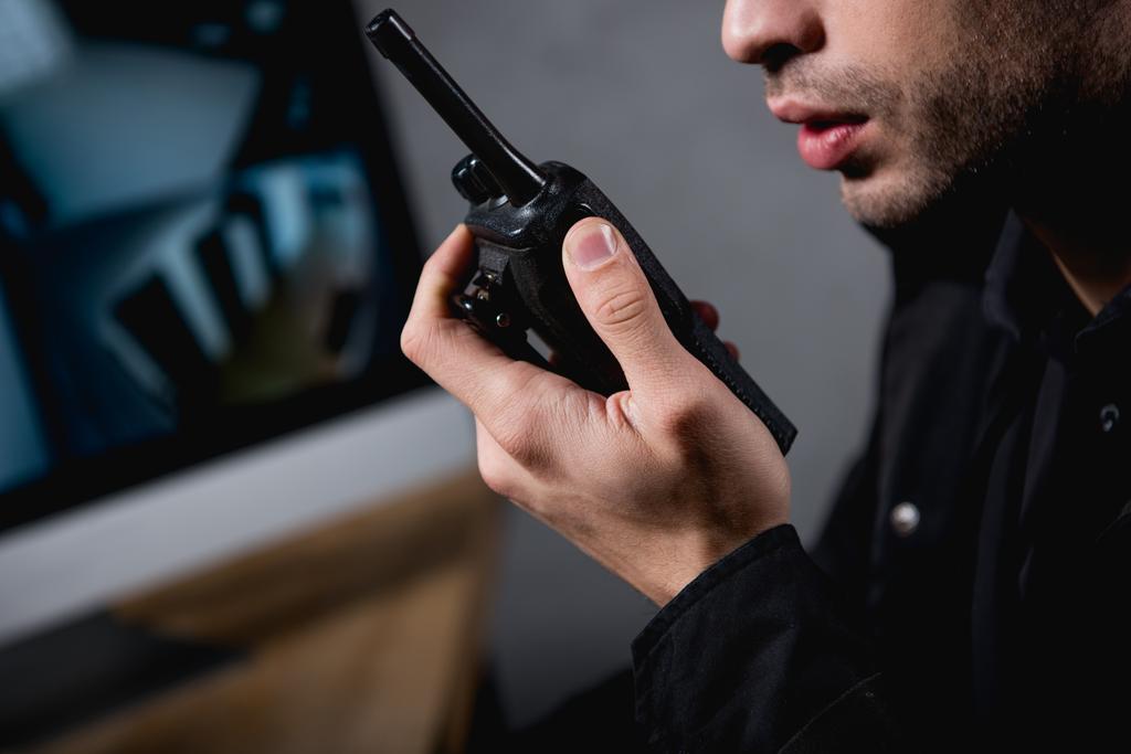 visão parcial do guarda segurando walkie-talkie no local de trabalho
  - Foto, Imagem