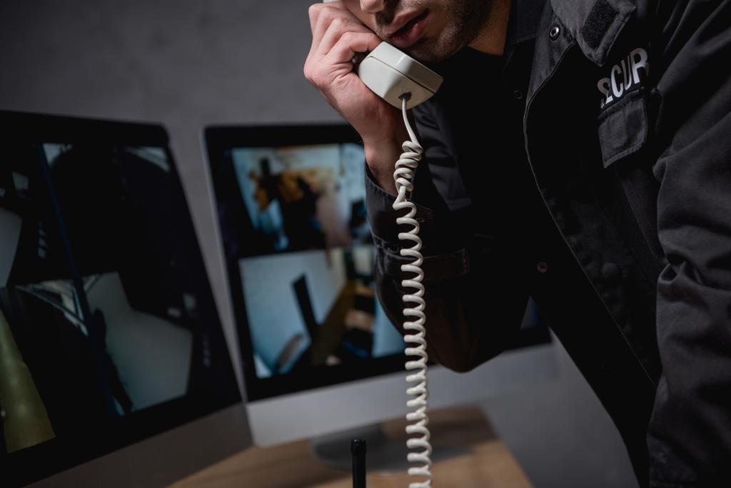 visão parcial do guarda falando por telefone no espaço de trabalho
  - Foto, Imagem
