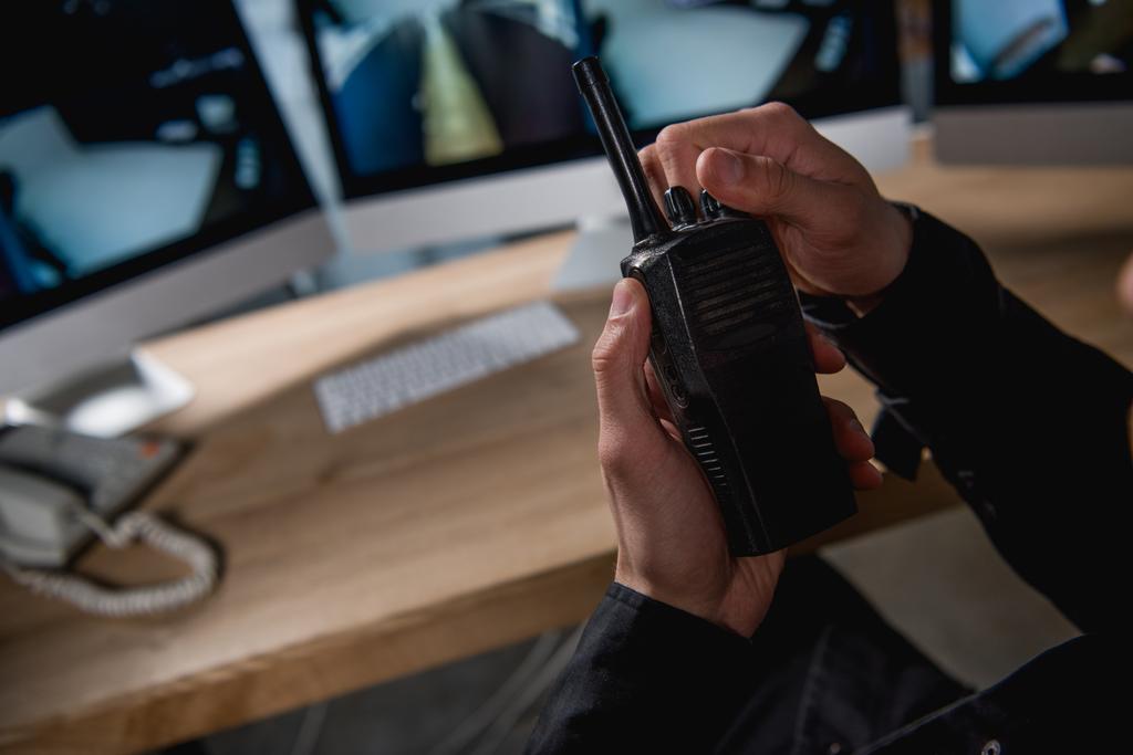 περικοπεί προβολή της φρουράς κρατώντας walkie-talkie στο χώρο εργασίας  - Φωτογραφία, εικόνα