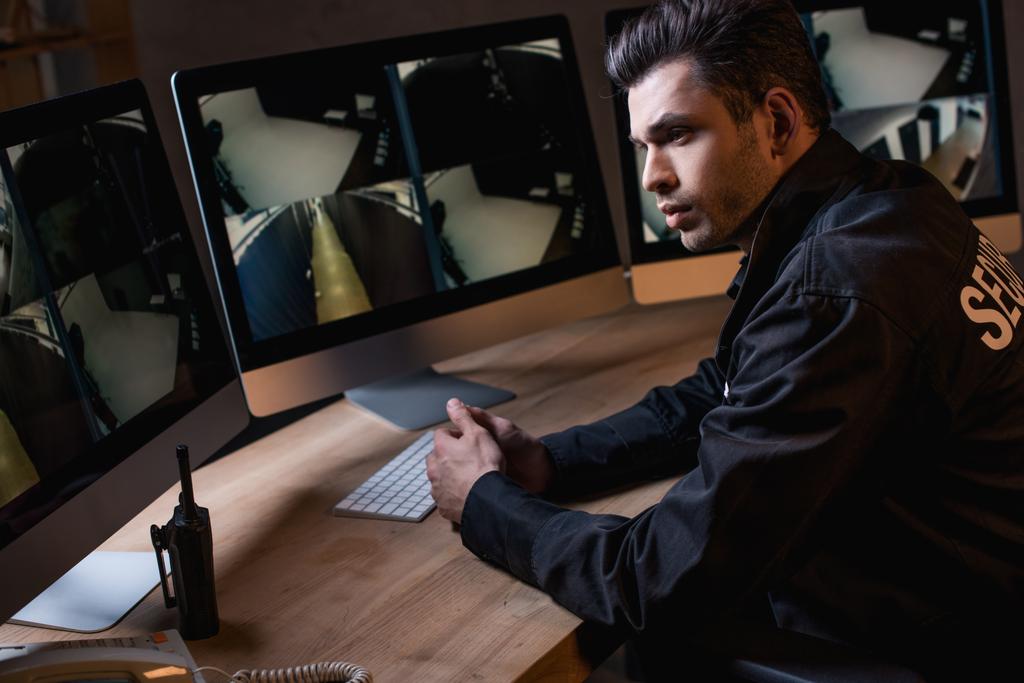 protector reflexivo en uniforme mirando monitor de la computadora
  - Foto, imagen