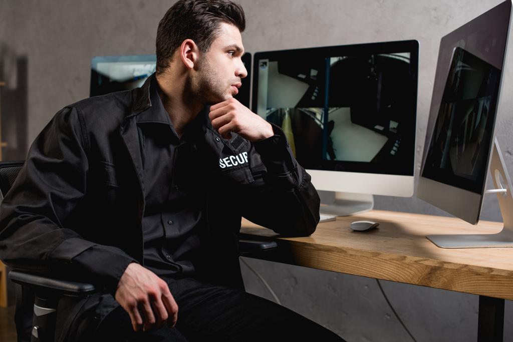 guardia concentrata in uniforme guardando il monitor del computer sul posto di lavoro
  - Foto, immagini