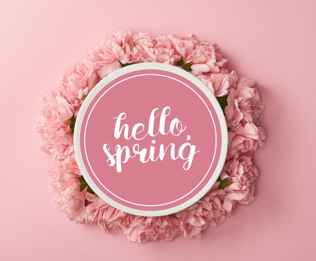 Widok płytki z hello z góry wiosna napis i wieniec różowe goździki na różowym tle - Zdjęcie, obraz
