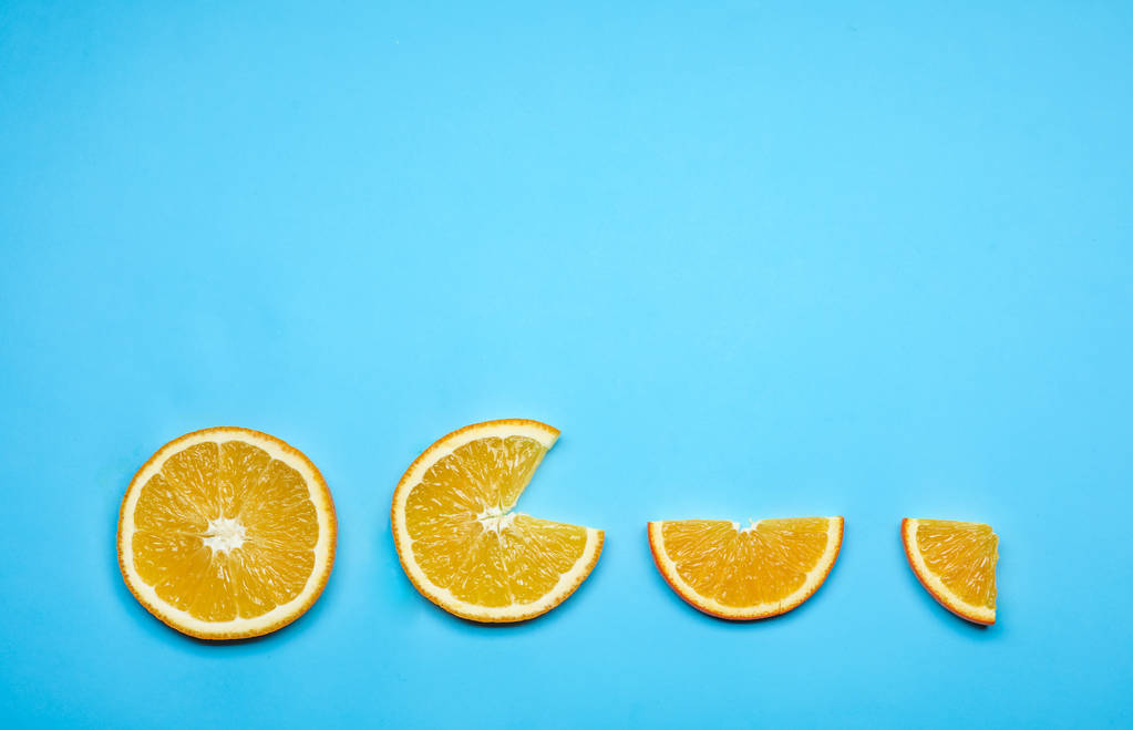 Samenstelling met verse stukjes sinaasappel en ruimte voor tekst op een achtergrond met kleur, plat leggen - Foto, afbeelding