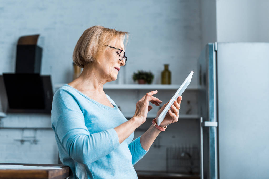 Mujer mayor usando tableta digital en casa - Foto, imagen