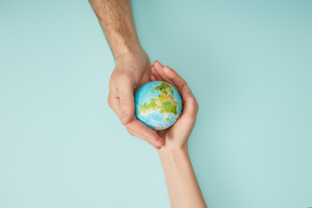 erkek ve kadın gezegen modeli turkuaz arka planda, dünya gün kavramı holding Üstten Görünüm - Fotoğraf, Görsel