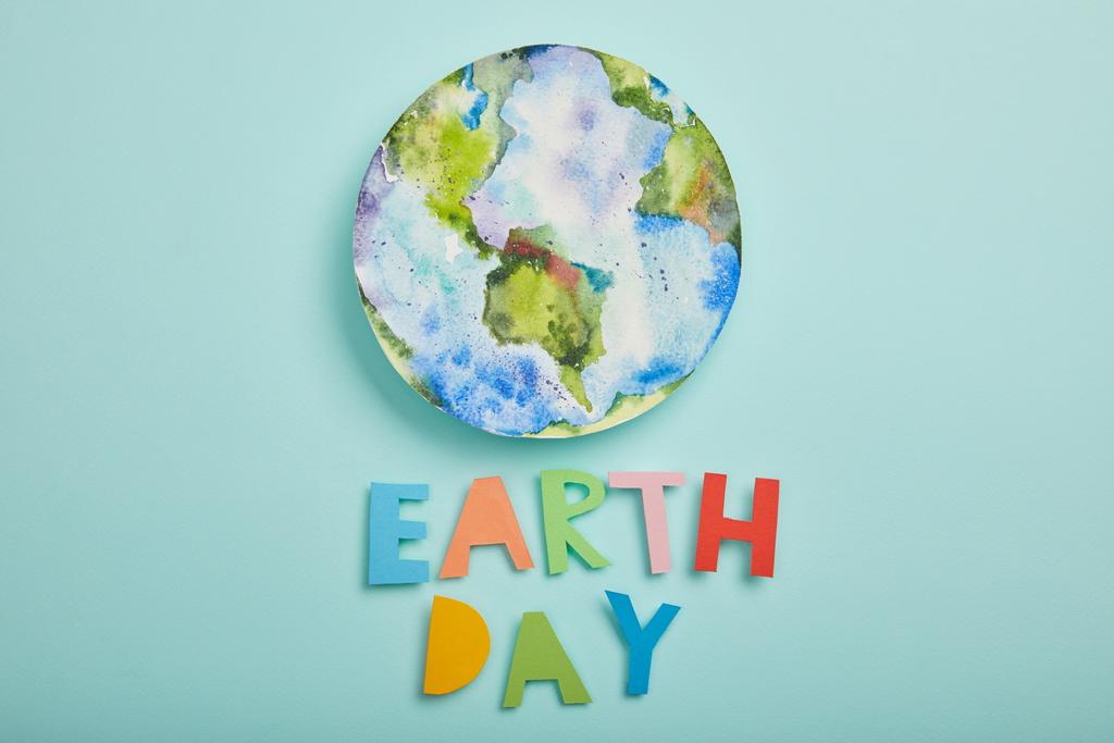 vista superior de letras de papel coloridas e imagem do planeta no fundo azul-turquesa, conceito de dia de terra
 - Foto, Imagem