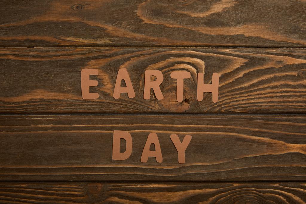 top view of paper letters on brown wooden background, earth day concept - Photo, Image