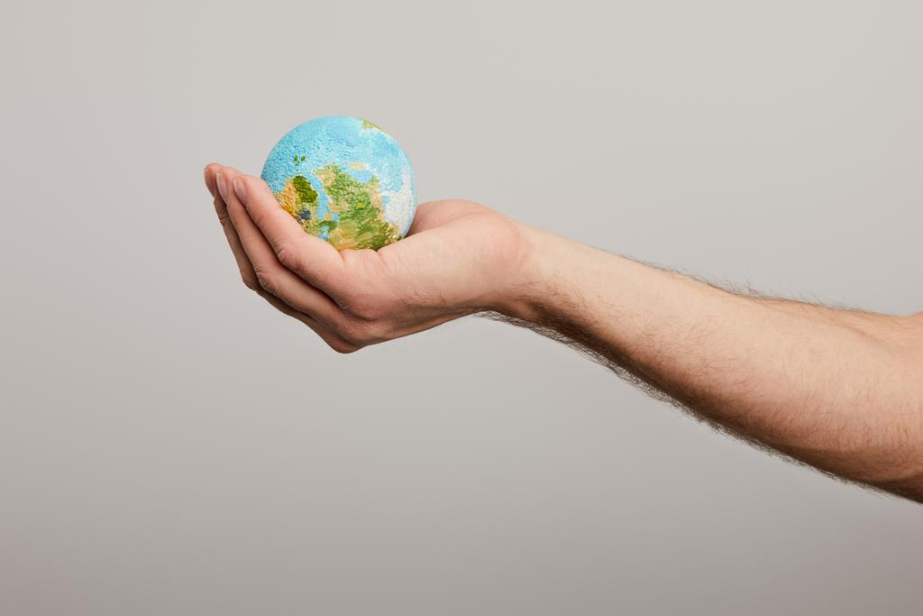 Mann hält Planetenmodell auf grauem Hintergrund, Earth Day Konzept - Foto, Bild