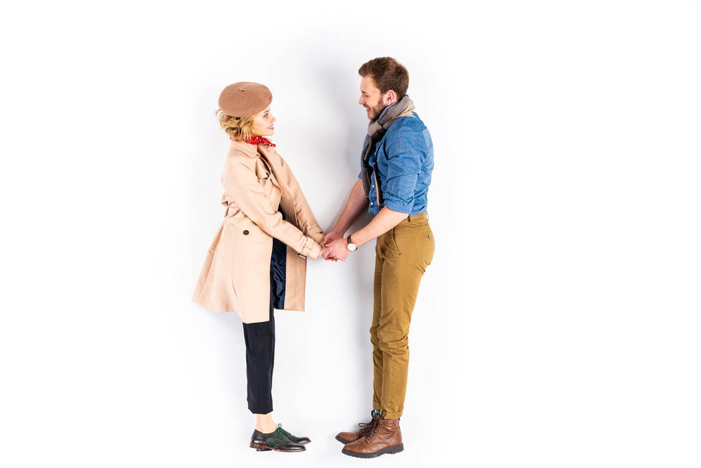 Vue latérale d'un couple heureux se regardant et se tenant la main sur fond blanc
 - Photo, image