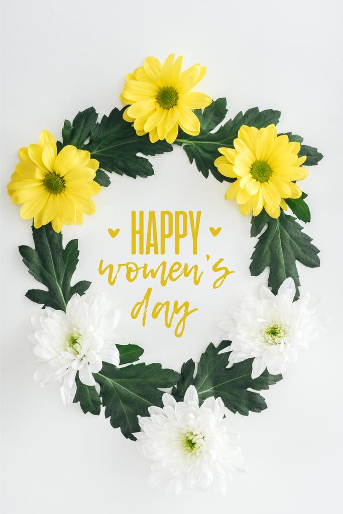 bovenaanzicht van de krans met witte en gele madeliefjes en groene bladeren op een witte achtergrond met gelukkig womens dag illustratie - Foto, afbeelding