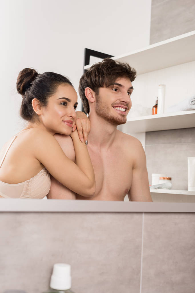paidaton mies ja nainen pitsi alusvaatteet halaa ja hymyilee kylpyhuoneessa
  - Valokuva, kuva