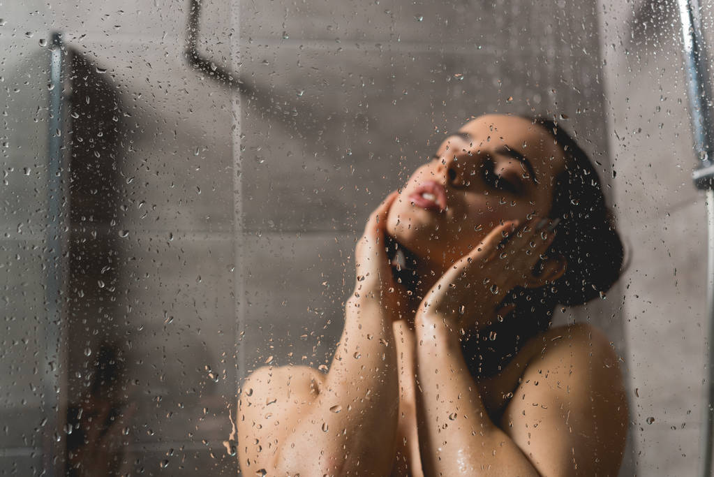 selective focus  of beautiful and naked woman taking shower in cabin  - Photo, Image