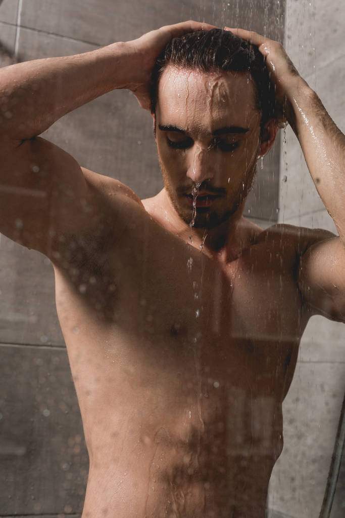 handsome and brunette man taking shower in cabin  - Photo, Image