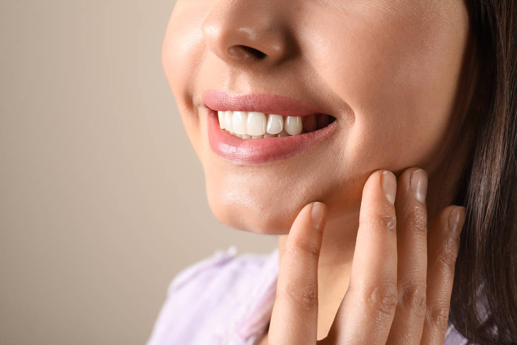 Mujer joven con dientes sanos sobre fondo de color, primer plano
 - Foto, imagen