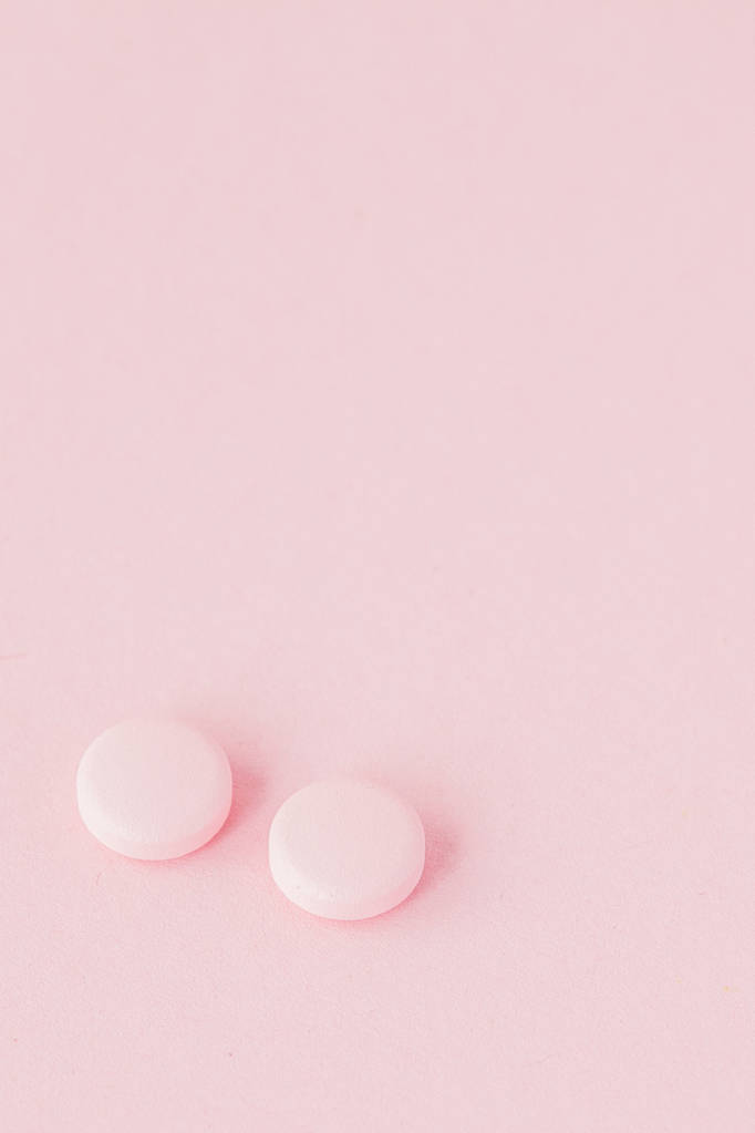 Rózsaszín tabletták egy rózsaszín háttér, másol hely. - Fotó, kép