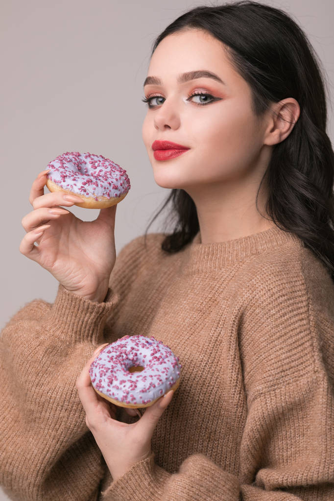 Красивая девушка с красными губами, позирующая с пончиком и аппликацией.
. - Фото, изображение