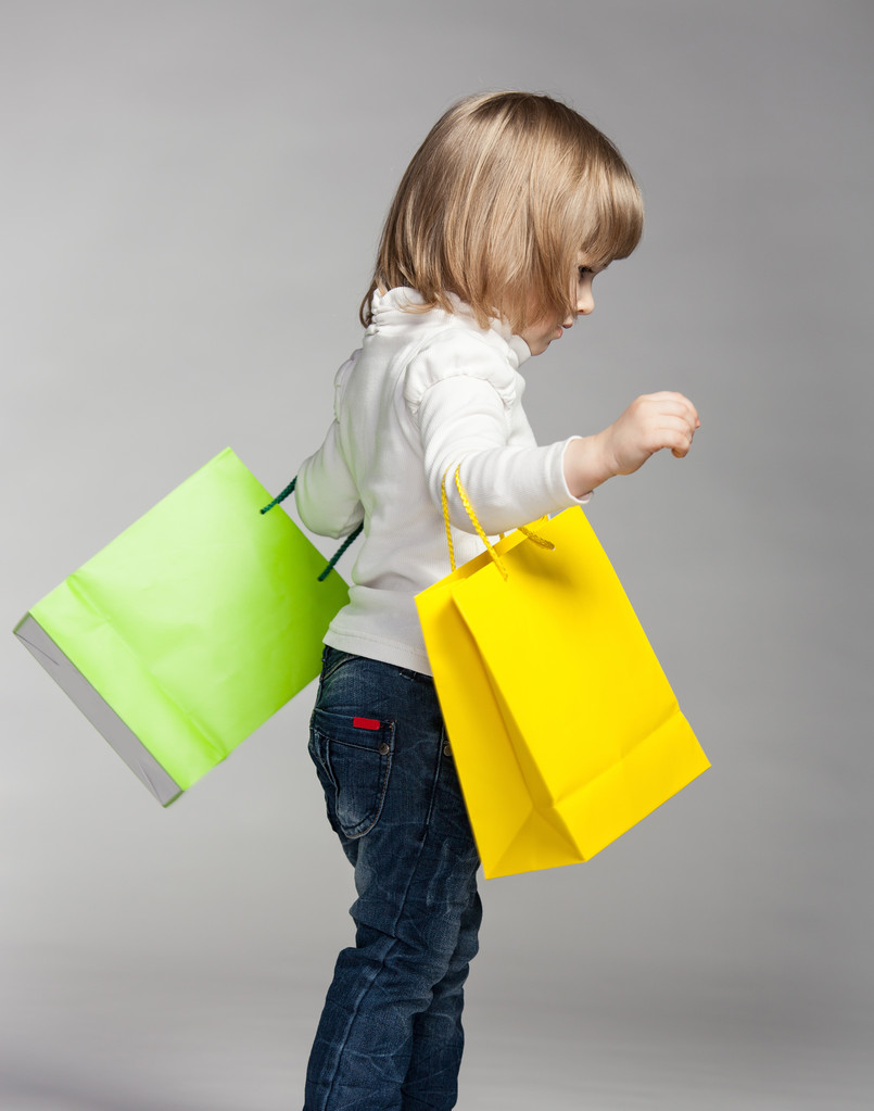 kleines Mädchen mit bunten Einkaufstaschen - Foto, Bild