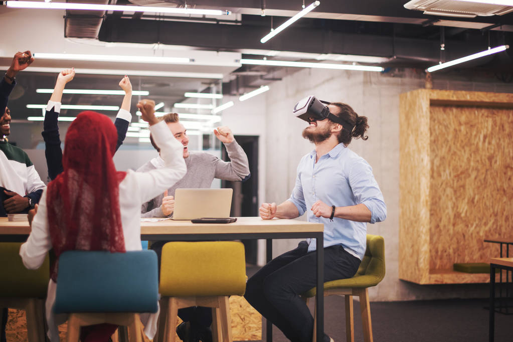 Мультиетнічна бізнес-команда використовує шолом віртуальної реальності в офісі зустрічі розробників з симулятором віртуальної реальності за столом у творчому кабінеті. - Фото, зображення
