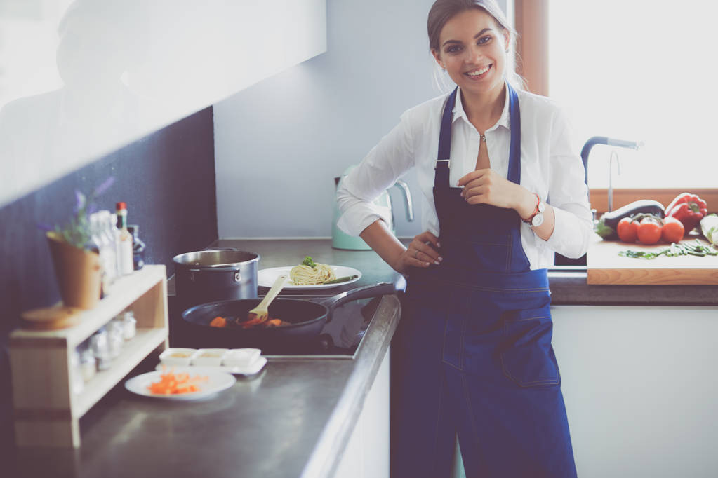 Portré fiatal nő álló karokkal keresztbe konyha háttér - Fotó, kép