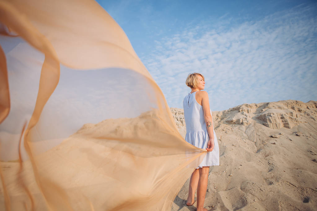 meisje met een lichte sluier en de wind in de woestijn spreiden haar vleugels - Foto, afbeelding