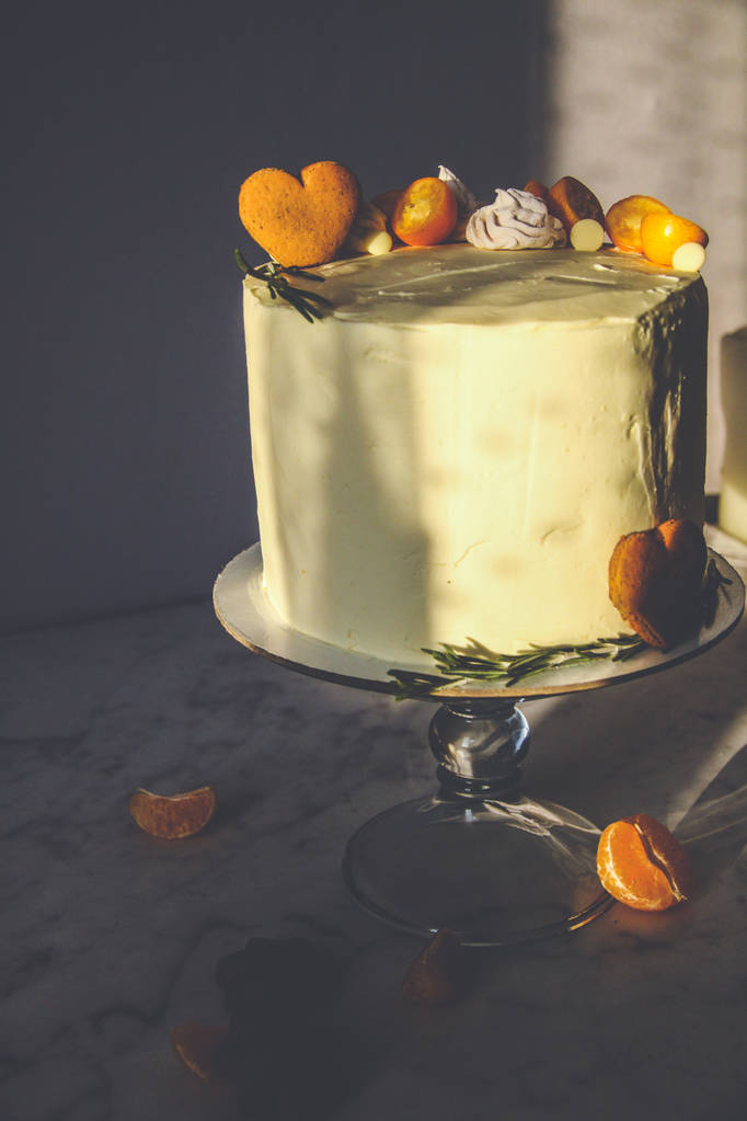 Gâteau blanc, décoré de biscuits au gingembre, guimauves, sur un fond sombre
 - Photo, image