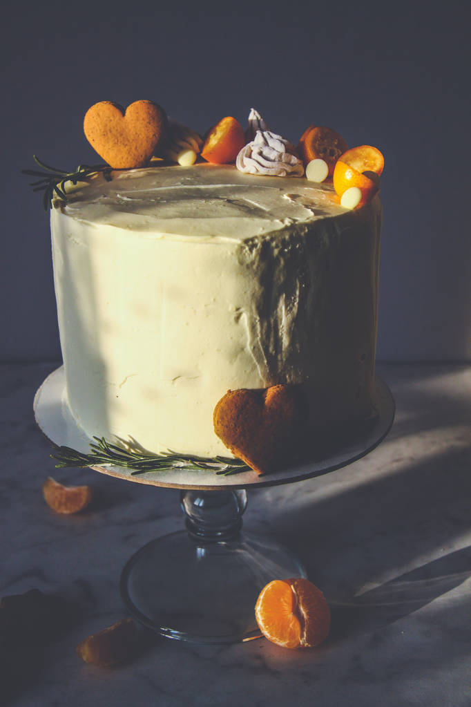 Valkoinen kakku, koristeltu inkivääri evästeet, vaahtokarkit, tummalla pohjalla
 - Valokuva, kuva