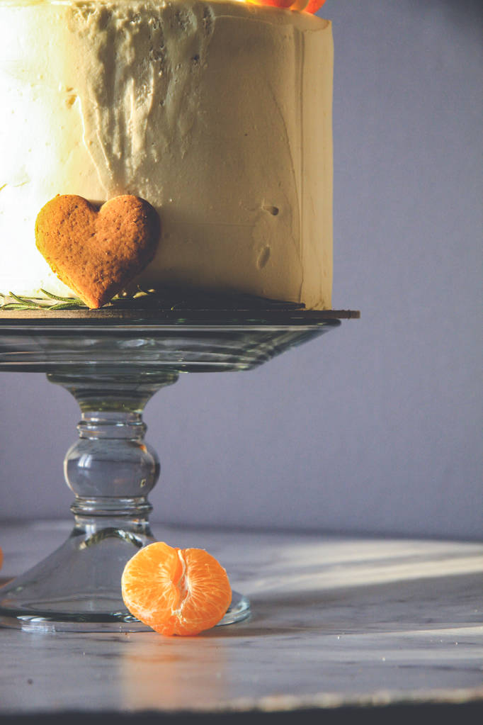 weißer Kuchen, dekoriert mit Ingwerkeksen, Marshmallows, auf dunklem Hintergrund - Foto, Bild
