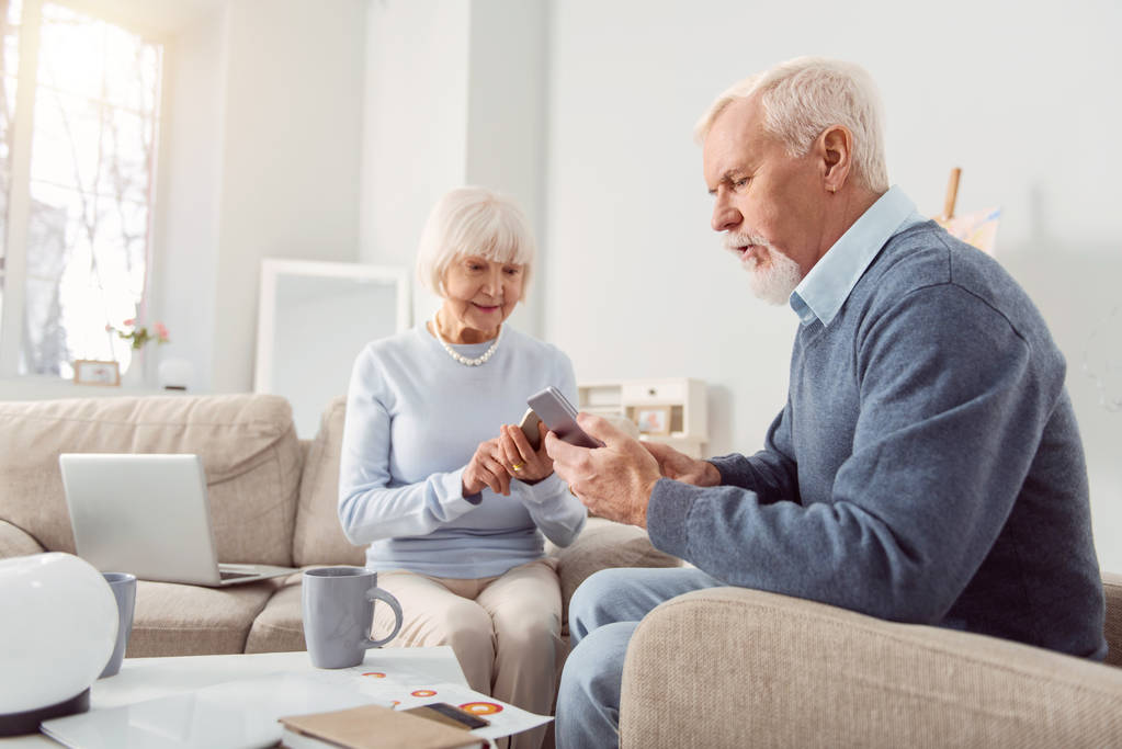 Aangename bejaarde echtpaar wordt vastgelijmd aan hun telefoons - Foto, afbeelding