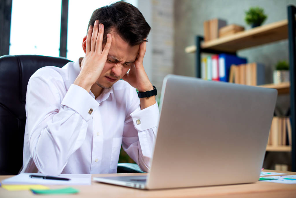 Stressed young businessman shocked by bad news using laptop at work, desperate bankrupt investor lost money, financial problem debt, tired of overwork. - Photo, Image