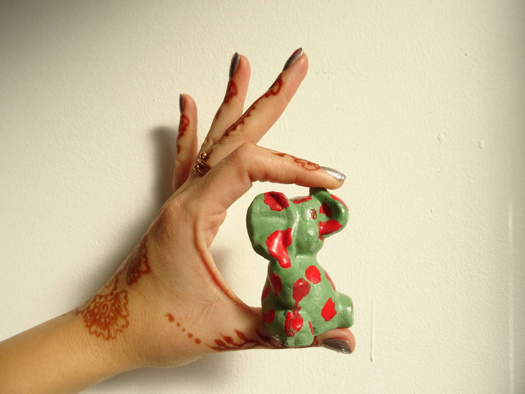 Zöld elefánt figura egy női kéz indiai piros pontok - Fotó, kép