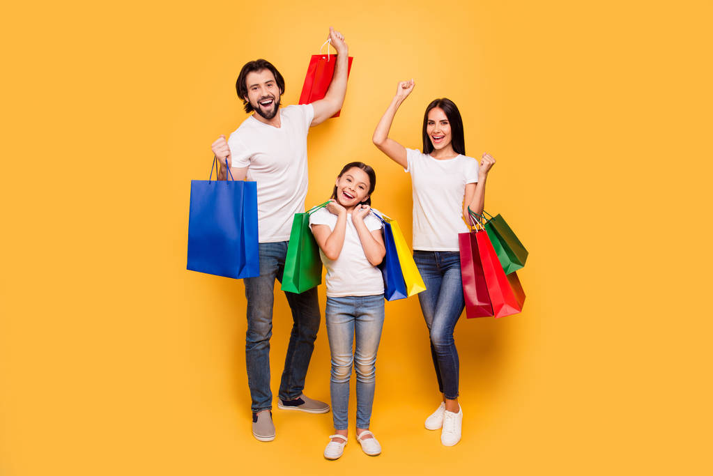 Full length body size view portrait of nice attractive trendy cheerful people holding in hands bags with new clothes having fun rejoice isolated over shine vivid pastel yellow background - Photo, Image