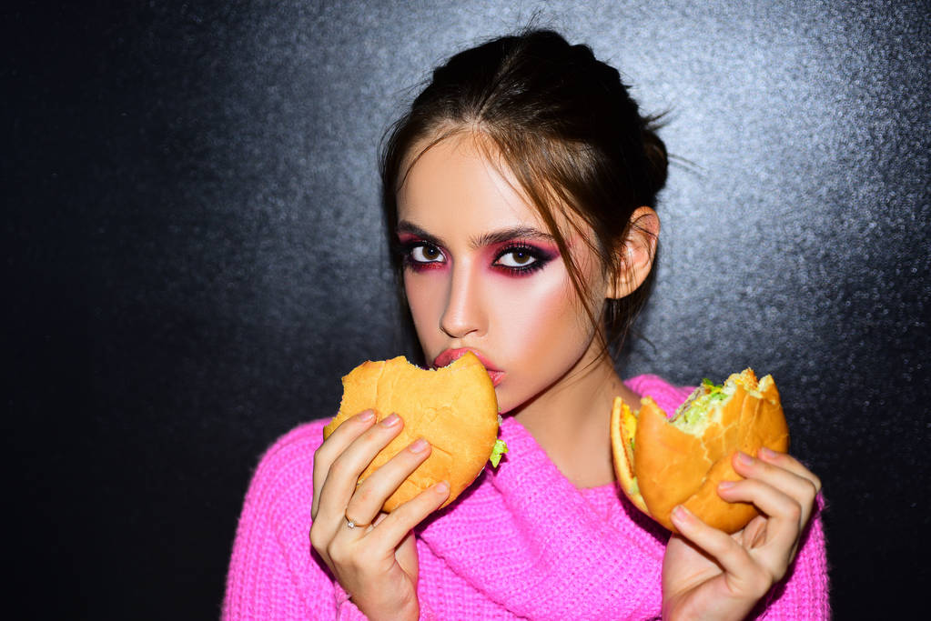 Beauty woman face. Sexy woman eating hamburger. Food porn. Female beauty visage concept. - Photo, Image