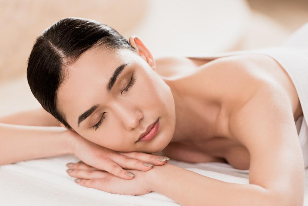 mooie Aziatische vrouw rusten met gesloten ogen in spa  - Foto, afbeelding
