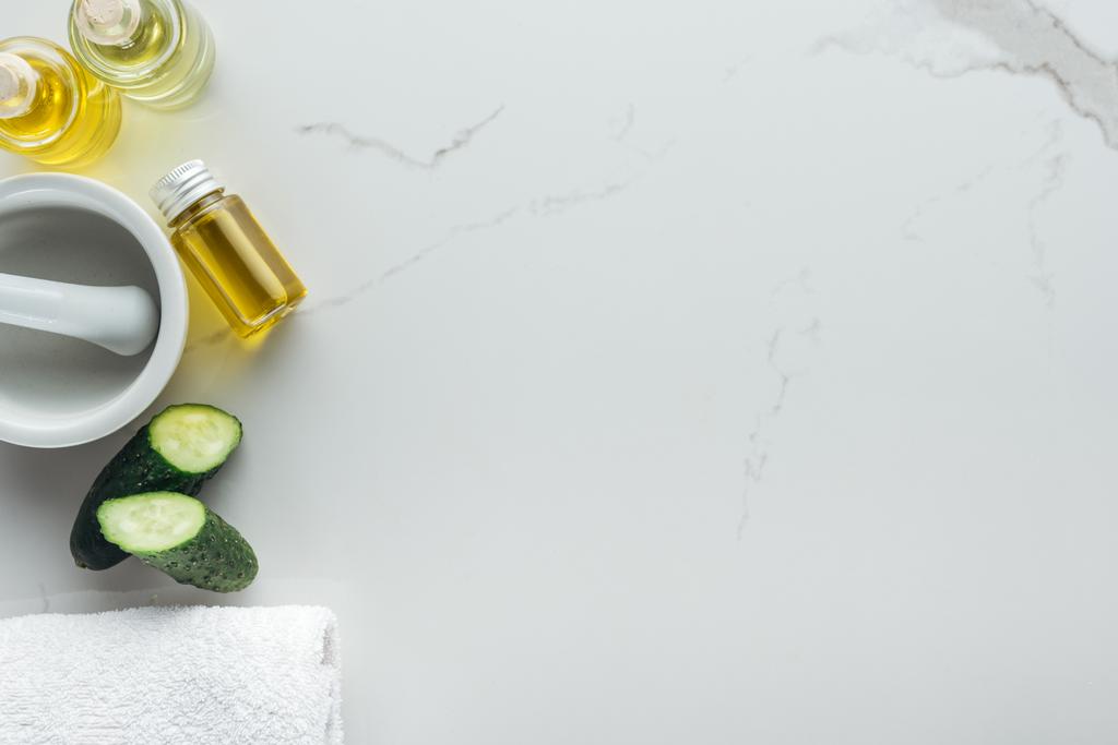 bovenaanzicht van gesneden komkommer, Ponder en verschillende natuurlijke ingrediënten voor handgemaakte cosmetica op witte ondergrond - Foto, afbeelding