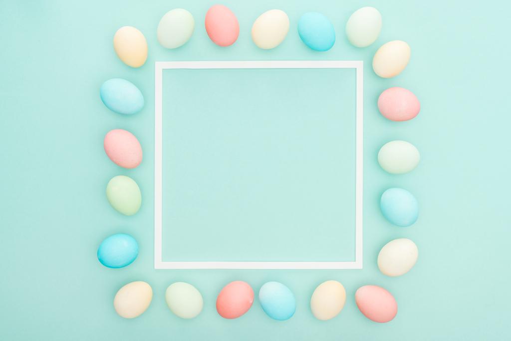 vista dall'alto di pastello uova di Pasqua vicino cornice vuota isolato su blu
 - Foto, immagini