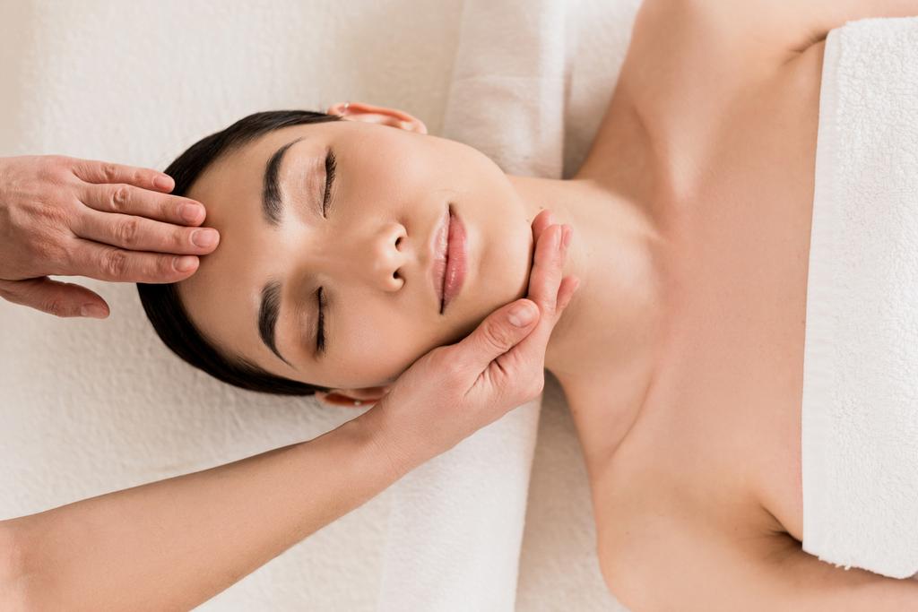 attrayant femme obtenir massage du visage avec les yeux fermés au spa
  - Photo, image