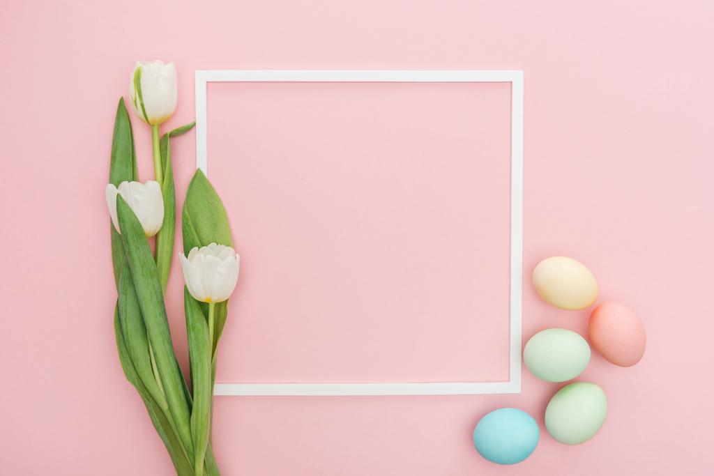 top view of frame with tulips and pastel easter eggs isolated on pink - Photo, Image
