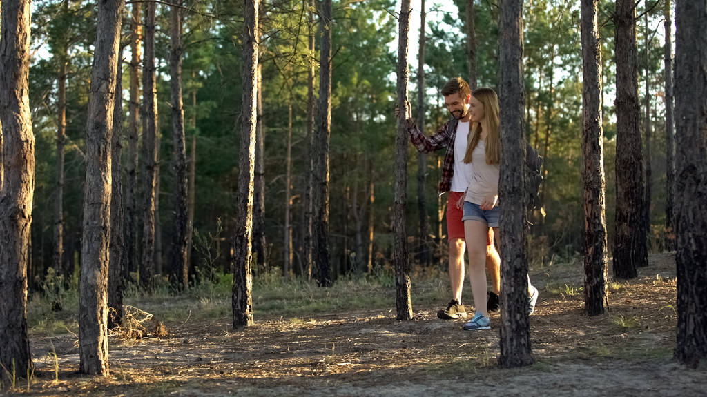 Pareja joven con bolsas turísticas ir de camping en madera pintoresca, fin de semana romántico
 - Foto, imagen